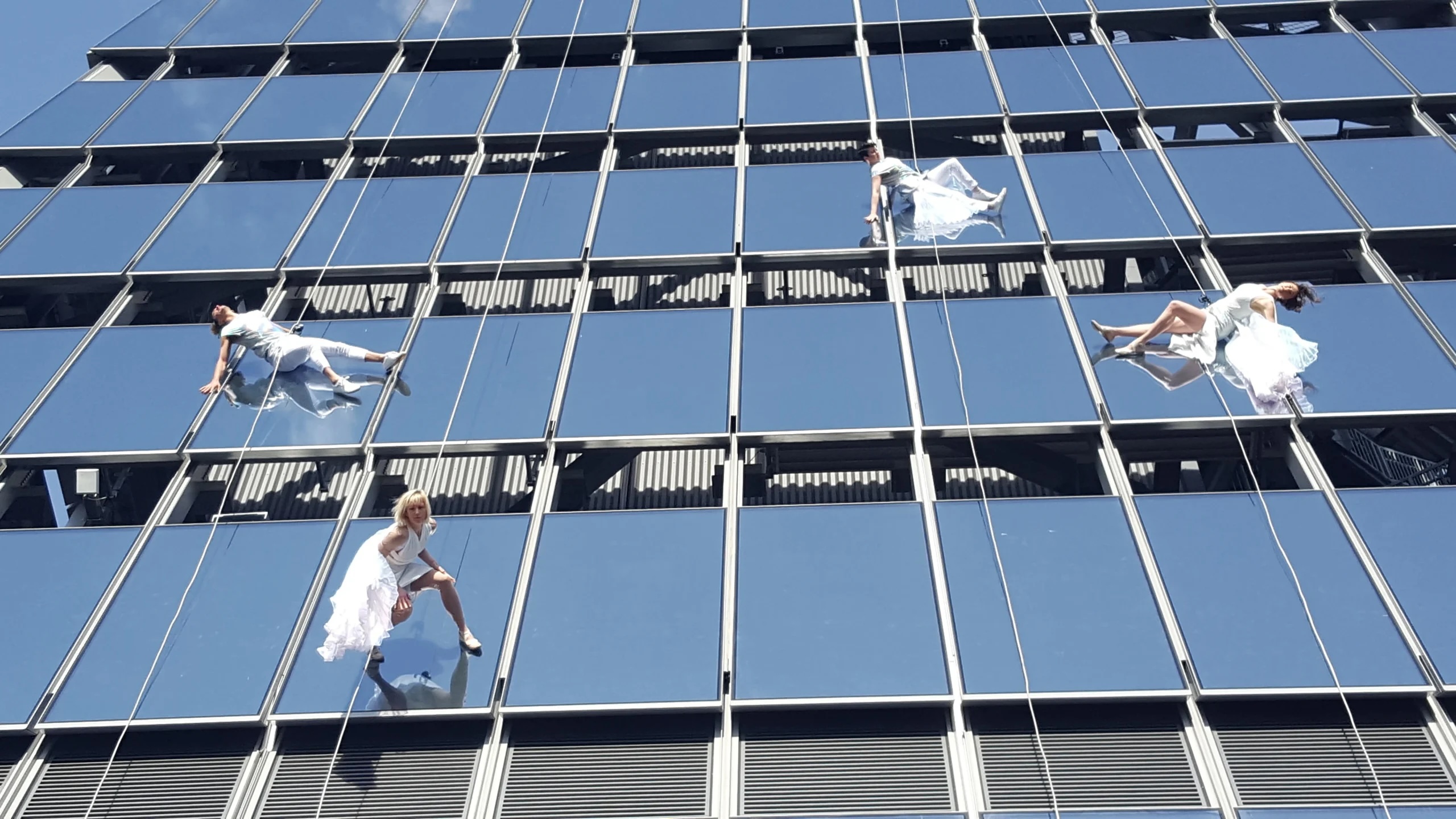 Bandaloop performing while dangling off of The Edge building
