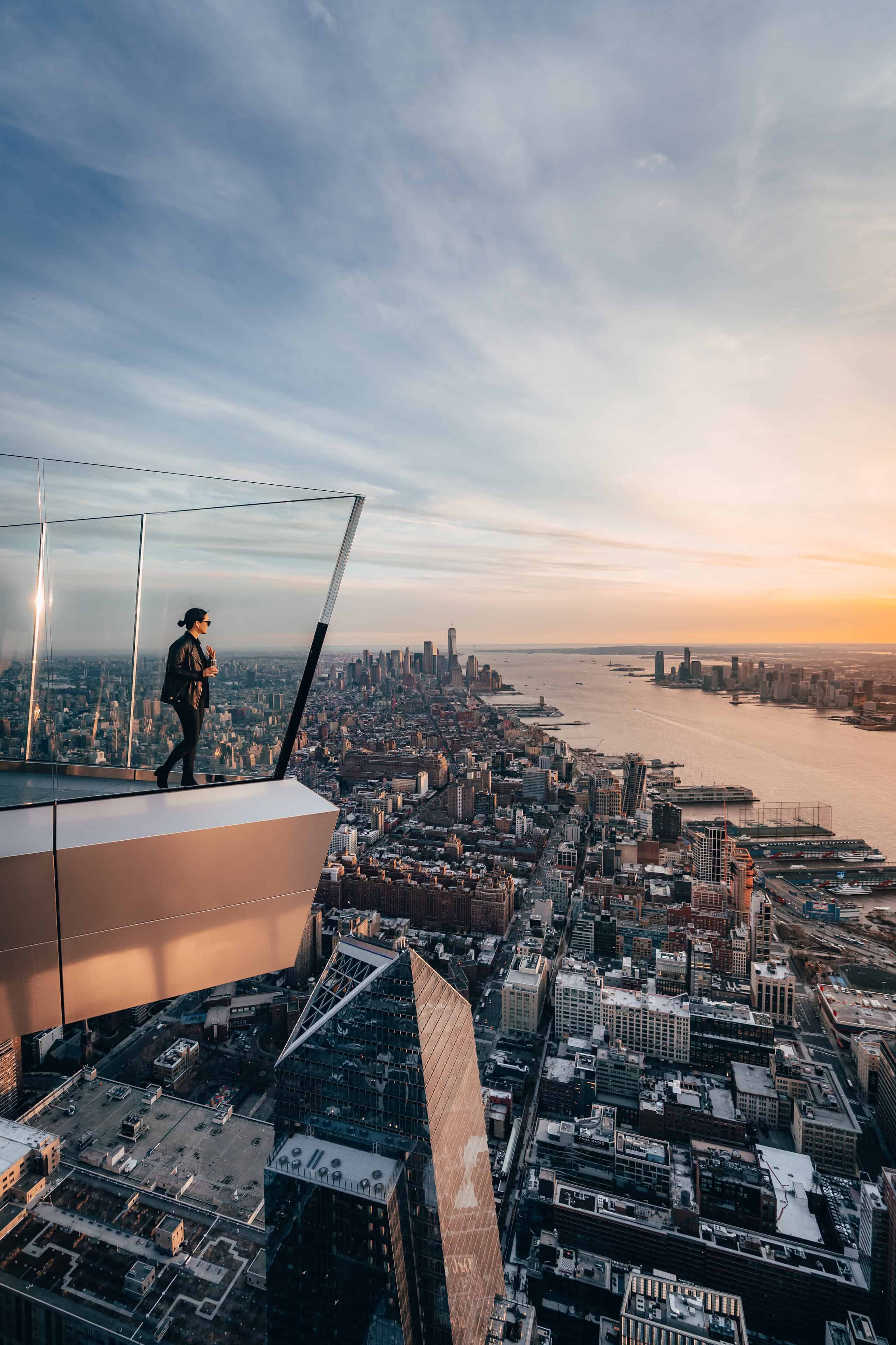 A woman steps onto The Edge overlooking New York City at night