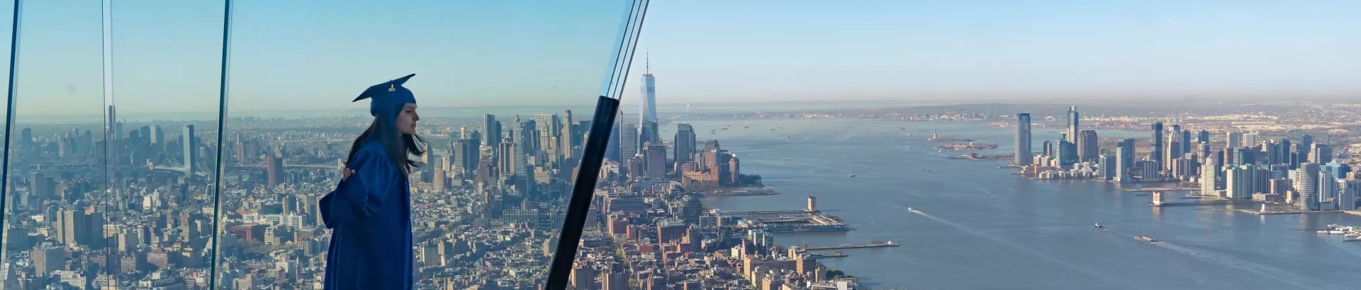 A young woman in graduation robes and hat looks out at New York City from The Edge