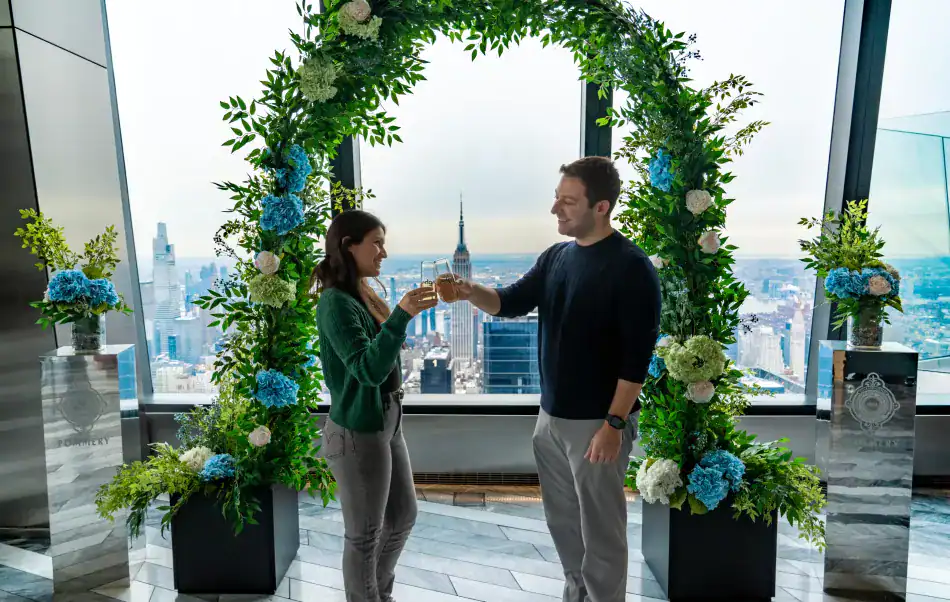 A couple clinks glasses at The Edge