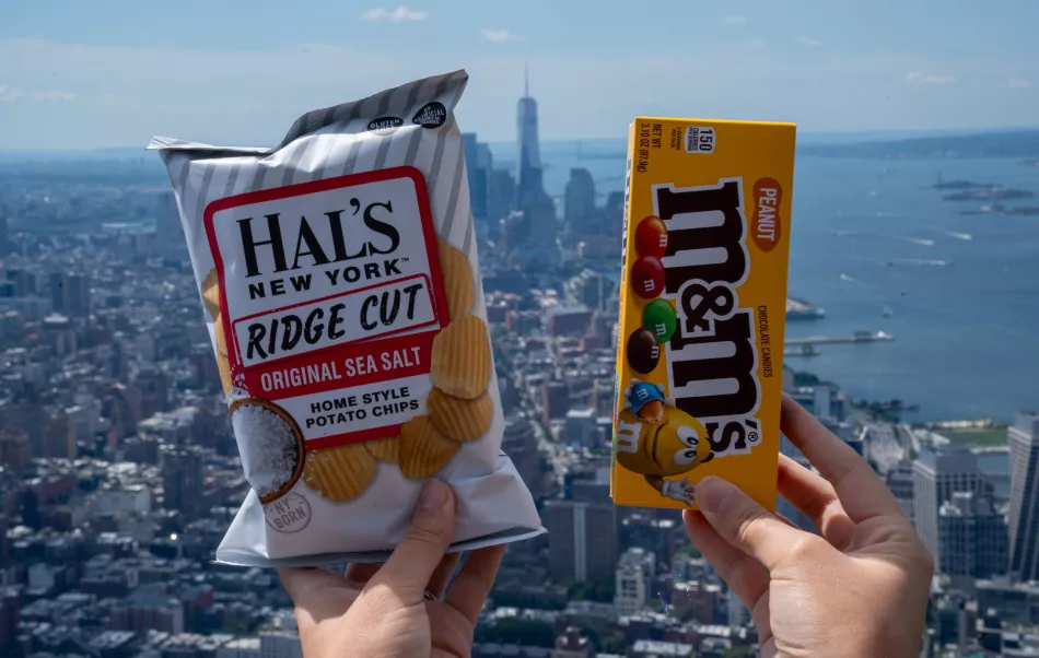 A person holds up chips and candy at The edge