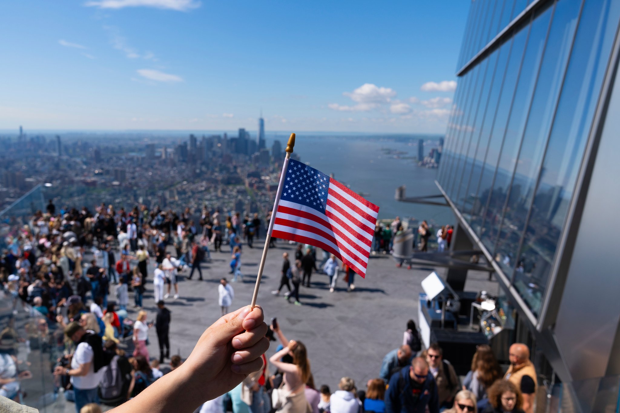 Person holding small American flag on the Edge sky deck