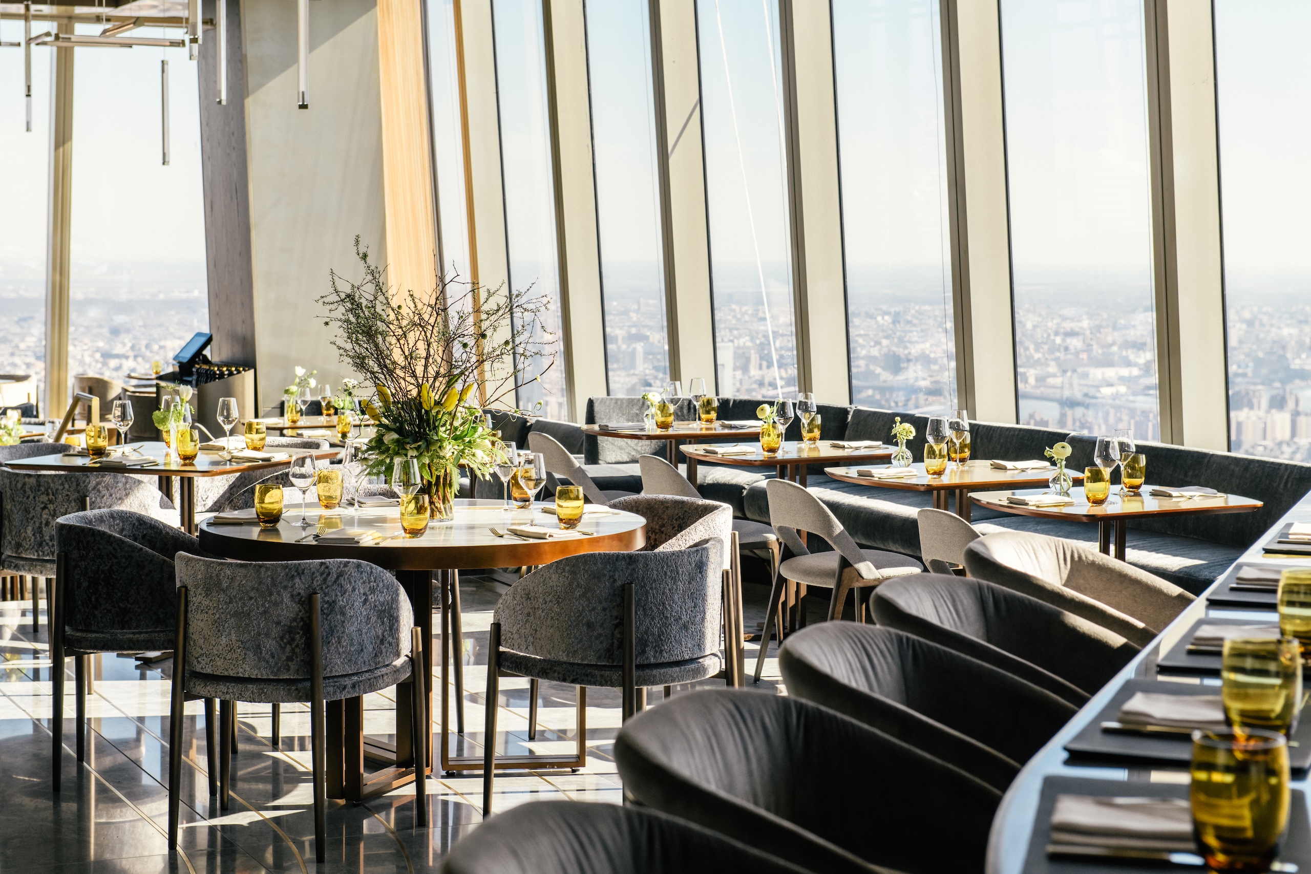 The main dining room at Peak overlooking New York on a sunny day