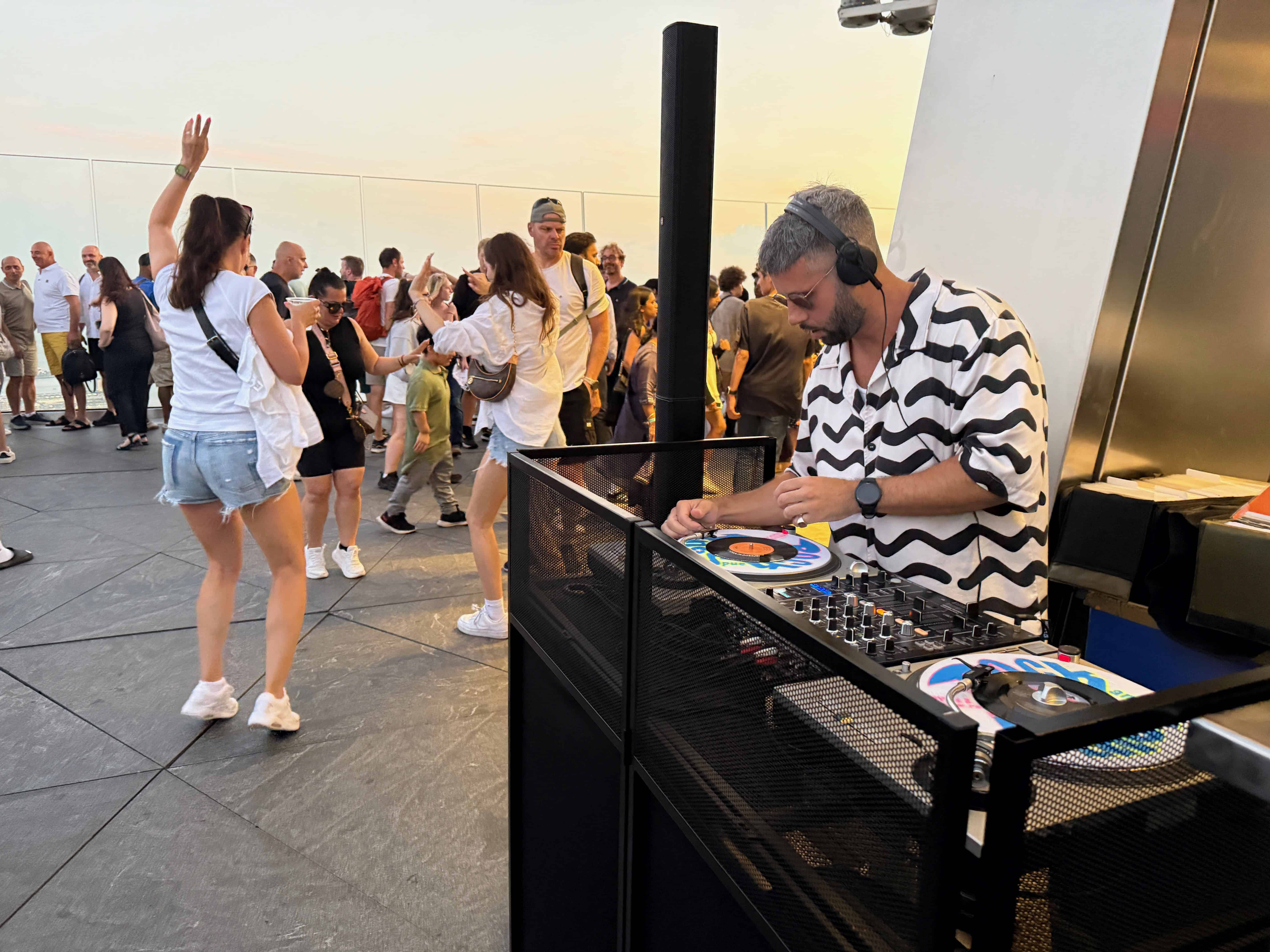 dj performing outside at The Edge with people dancing around him