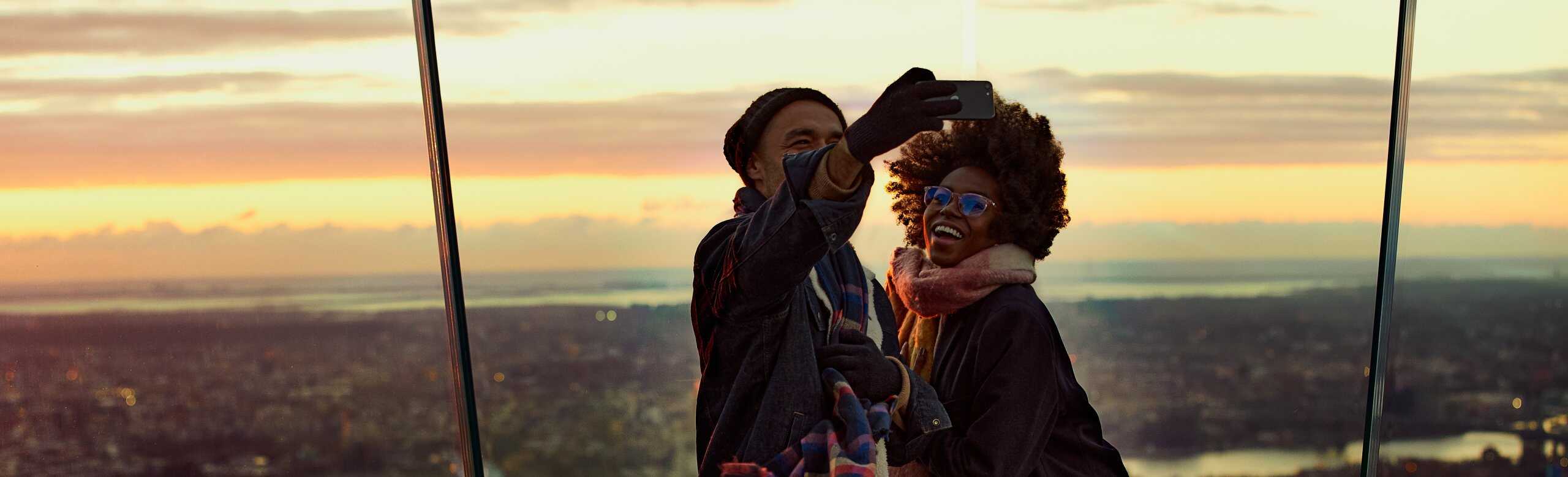Ein Paar posiert für ein Selfie am östlichen Punkt von The Edge NYC bei Sonnenuntergang