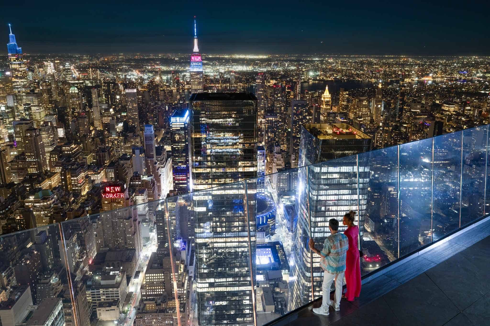 a couple looking out at the nyc skyline at night from the edge nyc