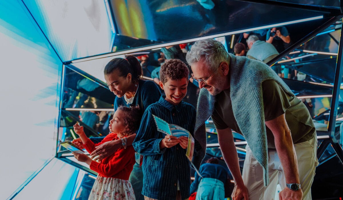Family and children exploring the immersive Edge NYC sky deck with panoramic views.