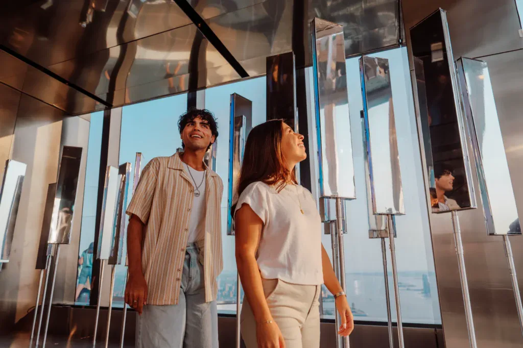 Visitors at Edge NYC Sky Deck - Edge NYC - Edge NYC Two people enjoying panoramic skyline views from Edge NYC sky deck.